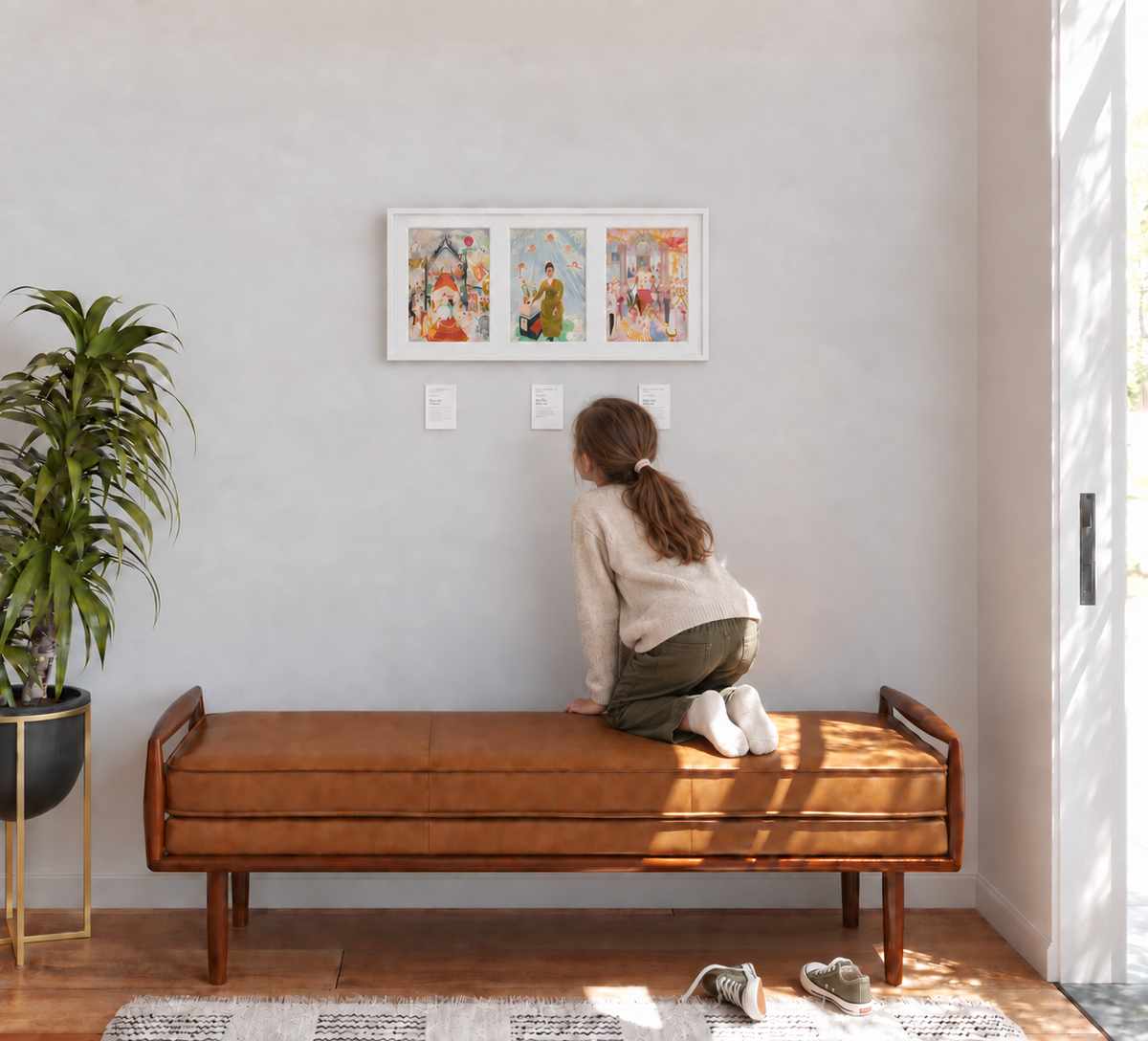 A child kneeling on a bench, leaning in to read the labels beneath
      three framed paintings.